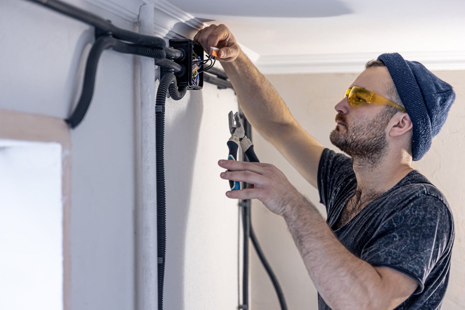 electrician is mounting electric sockets white wall indoors scaled